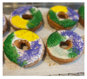 4 donuts with yellow, green, and purple sprinkles