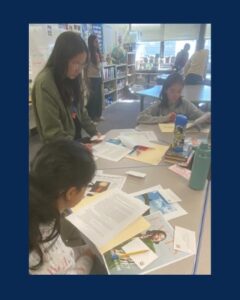 girls reading other students writing work