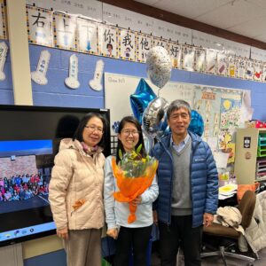 Ms. Shao standing with her parents after receiveing the D54 Blue Apple Award
